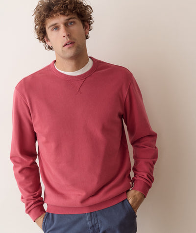 A dusty rose pink super soft crewneck sweatshirt laid flat against a neutral light gray background with full length sleeves